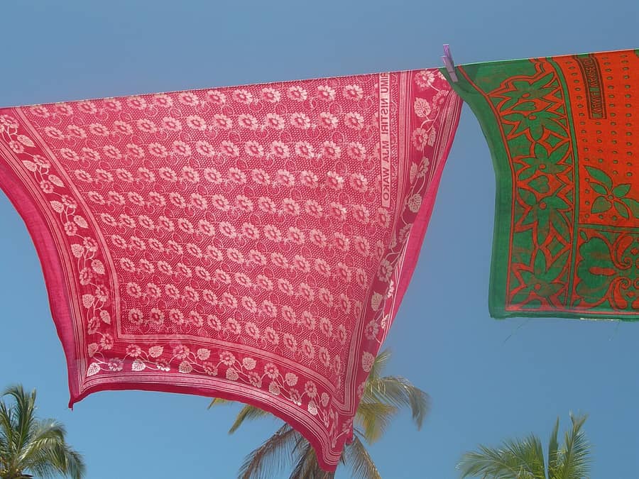 Deux kangas, des étoffes de coton imprimées, qui sèchent sur un fil à Zanzibar : l'étoffe dont sont faits les habits du proverbe.