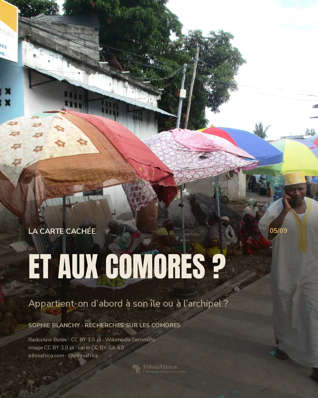 Un homme marche en téléphonant devant des vendeuses installées sous des parasols.