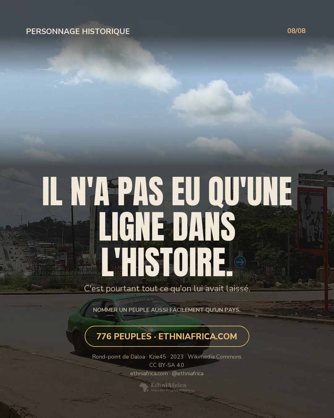 un rond-point urbain avec un monument central portant une antilope bondissante en silhouette et une fresque murale, des voitures et taxis verts en circulation, une large avenue bordée d'arbres à l'arrière-plan